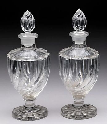 une paire de flacons de parfum en verre transparent posés sur une table