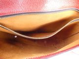 a red purse with a zipper on the inside of it