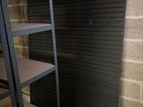 a shelf in the corner of a room with a brick wall