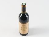 an old bottle of wine sitting on top of a white surface