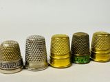 several thimbles are lined up in a row on a white surface