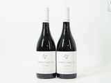 deux bouteilles de vin posées sur une table blanche