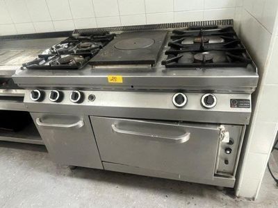 une cuisine équipée d'une cuisinière, d'un four et de placards