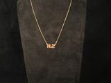 a gold necklace with the word love on it on a mannequin
