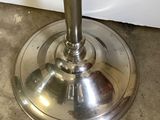 a metal table with a glass top and a metal base
