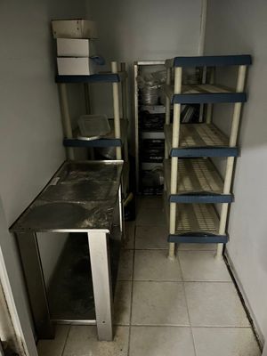 une photo d'une cuisine avec un réfrigérateur et des étagères