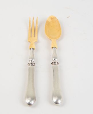 pair of silver plated forks and spoons on a white surface