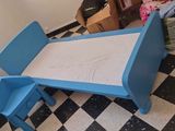 une table bleue et deux chaises bleues dans une pièce