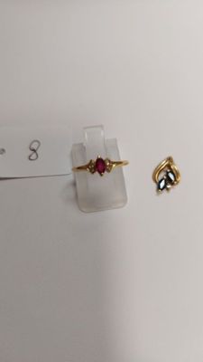 two rings and a ring on a display stand on a white surface