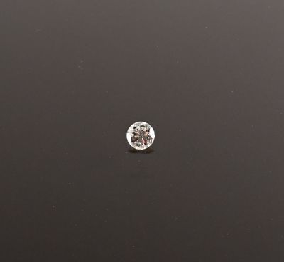 un gros plan d'un petit diamant blanc sur une surface noire