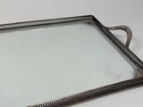 a silver tray with a handle on a white table