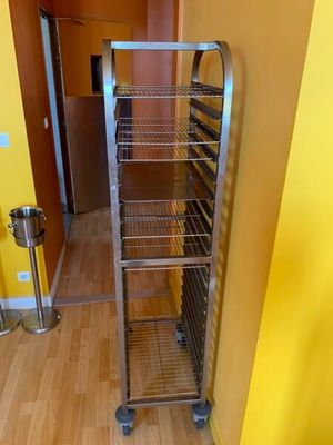 une photo d'une cuisine avec une étagère métallique au milieu de la pièce