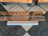 a picture of a wooden rack with a bunch of nails