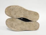 pair of brown shoes with black soles on a white surface