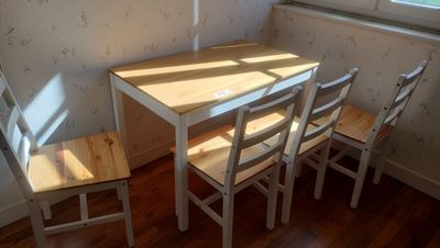 a small table and four chairs in the corner of the room