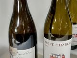 three bottles of wine are lined up on a white surface