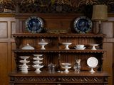 une grande armoire en bois sur laquelle sont posées plusieurs assiettes