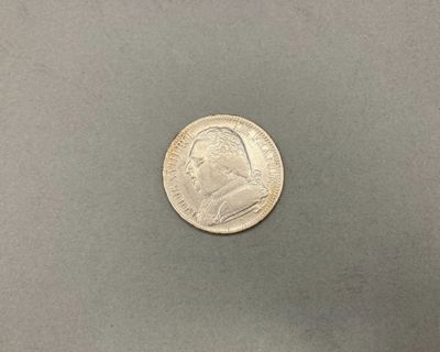 un gros plan d'une pièce de monnaie posée sur une surface grise
