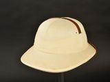 a white hat on a stand against a black background