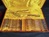 many forks and spoons in a case on a table