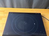 a close up of a black stove top on a wooden table
