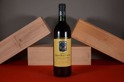 a bottle of wine sitting on a table next to two wooden boxes