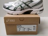 a white and green running shoe sitting on top of a box