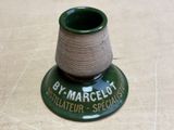 a green vase with a spool of thread on it