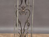 wrought iron plant stand with a glass top on a parquet floor
