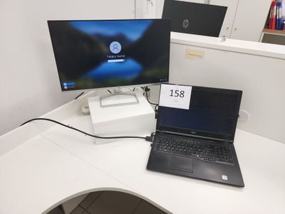 un ordinateur portable et un écran posés sur un bureau, avec une étiquette de prix