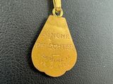 gold plated pendant with a tear shaped tag on it