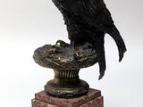 a statue of a bird sitting on top of a pedestal