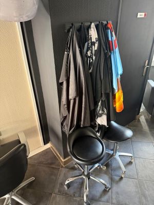 two chairs and a coat rack in the corner of a room