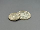 two coins sitting on top of each other on a table