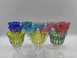 six verres à vin de couleurs et de motifs différents posés sur une surface blanche