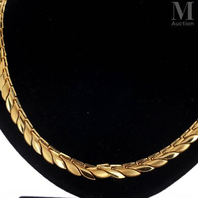 a close up of a gold necklace on a mannequin display