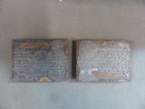 two pieces of metal with writing on them on a table