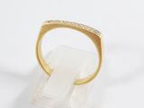 a close up of a gold ring with diamonds on a white surface