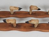 cinq moutons posés sur un socle en bois, sur fond blanc
