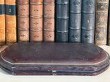 many old books lined up on a shelf next to each other