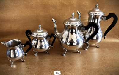 four silver teapots and two silver cups on a table