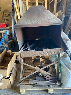 un grand four métallique posé sur une palette dans un garage