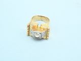 a gold and diamond ring sitting on a white surface
