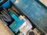 a blue box that has a drill and a cord in it