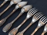 a lot of silver spoons and forks on a table