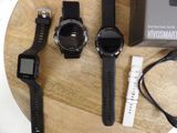 three smart watches sitting on a wooden table next to a charger