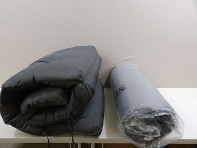 two pillows and a blanket on a white table