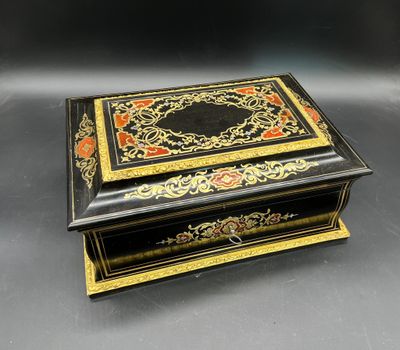 une boîte noire et dorée posée sur une table