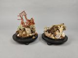 two small figurines of corals and shells on black bases