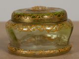 a green glass box with a gold decoration on it